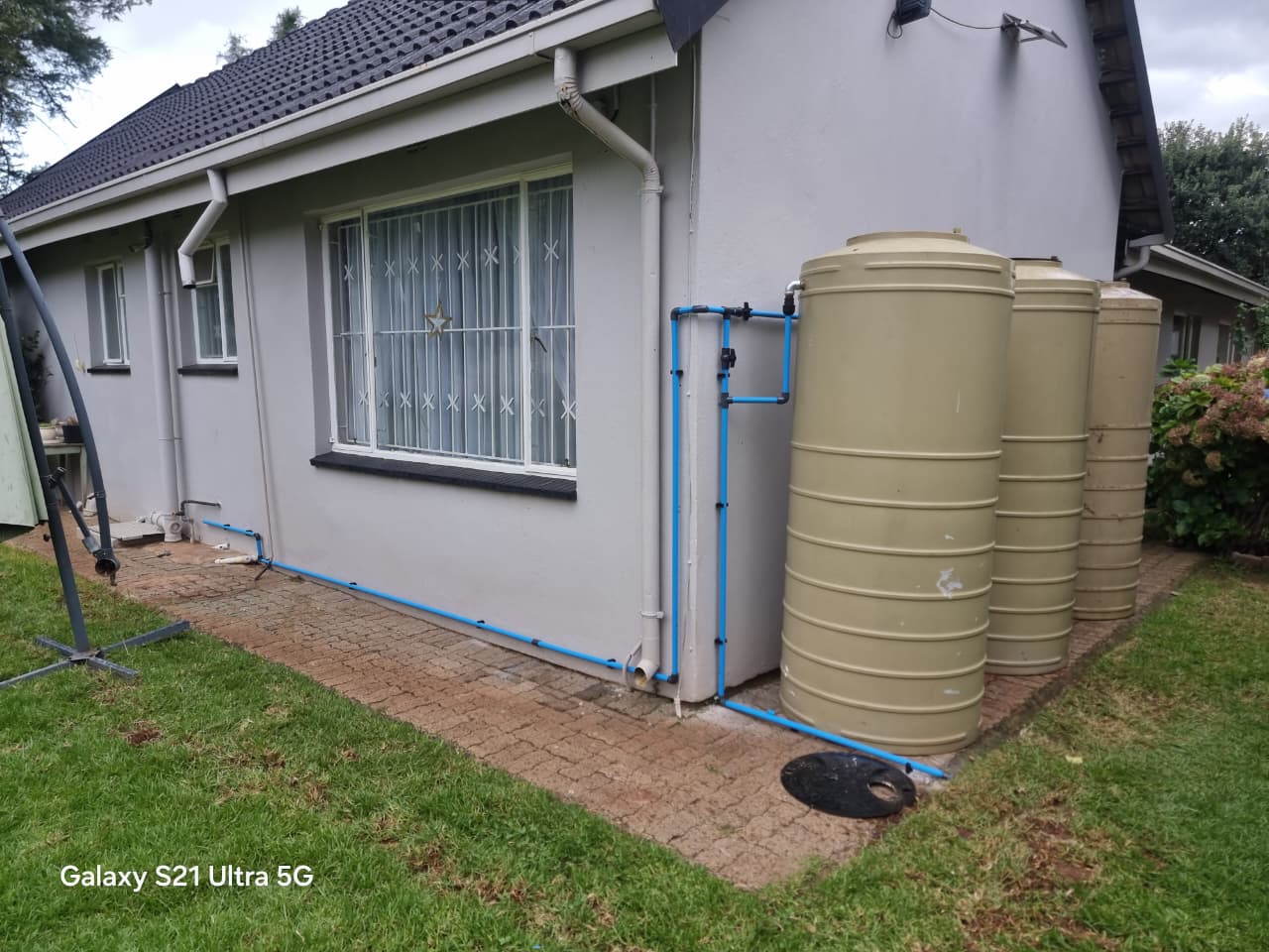 Rainwater harvesting tanks plumbed to a home's downpipe