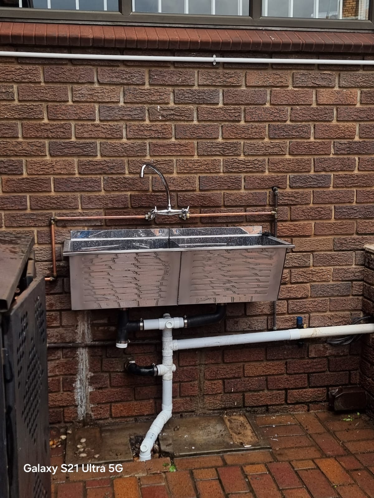 Outdoor stainless steel prep sink installed with copper pipework
