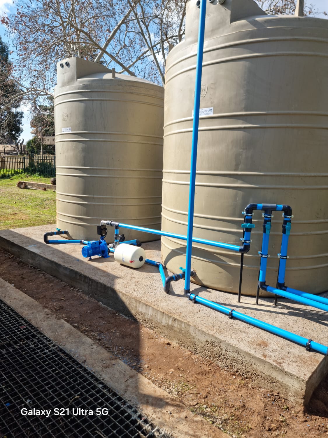 Water storage tanks with pump and blue pipework installed